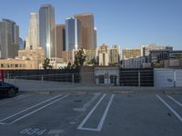 a parking lot has two parking meter and two red telephone booths in it, the city behind it