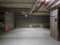 an empty parking garage with concrete floors and a sign with the name of a person on it