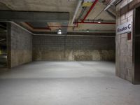 an empty parking garage with concrete floors and a sign with the name of a person on it