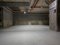 an empty parking garage with concrete floors and a sign with the name of a person on it