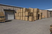 many boxes are sitting outside near a warehouse with a loading truck parked next to them