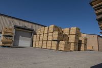 many boxes are sitting outside near a warehouse with a loading truck parked next to them