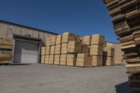 many boxes are sitting outside near a warehouse with a loading truck parked next to them