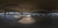 an empty building with a big curved ramp under it and some windows to the right