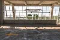 a large empty parking lot with lots of windows and arrow markings on the floor outside