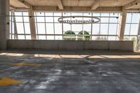 a large empty parking lot with lots of windows and arrow markings on the floor outside