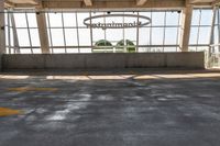 a large empty parking lot with lots of windows and arrow markings on the floor outside