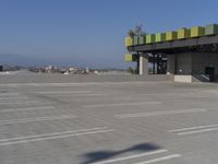 empty parking lot of commercial area with sky in background and street name sign above roof