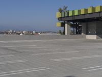 empty parking lot of commercial area with sky in background and street name sign above roof