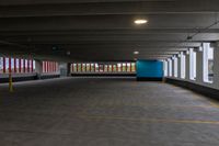 an empty parking garage with light posts in the distance and large windows in the background