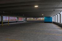 an empty parking garage with light posts in the distance and large windows in the background