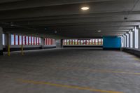 an empty parking garage with light posts in the distance and large windows in the background