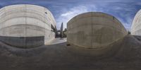 three concrete water tanks with a blue sky in the background on top of a ramp