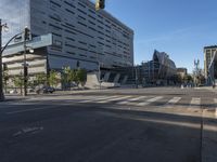 the corner of an empty street with several people on it's side and buildings around