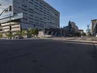 the corner of an empty street with several people on it's side and buildings around