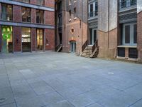 a building in the middle of a courtyard in the afternoon with stairs coming up to it