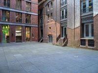 a building in the middle of a courtyard in the afternoon with stairs coming up to it