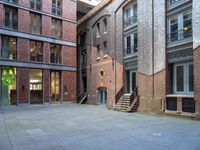 a building in the middle of a courtyard in the afternoon with stairs coming up to it