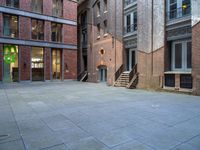 a building in the middle of a courtyard in the afternoon with stairs coming up to it