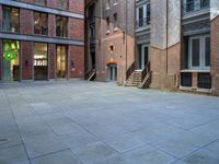 a building in the middle of a courtyard in the afternoon with stairs coming up to it