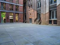 a building in the middle of a courtyard in the afternoon with stairs coming up to it