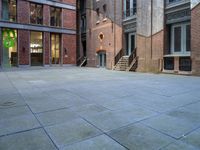 a building in the middle of a courtyard in the afternoon with stairs coming up to it