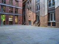 a building in the middle of a courtyard in the afternoon with stairs coming up to it