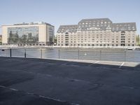 the city is next to an empty riverbed in a parking lot with a few buildings