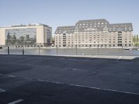 the city is next to an empty riverbed in a parking lot with a few buildings