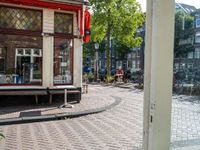 a dog sleeping on a bench in the street next to a bench next to buildings