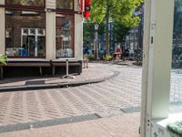 a dog sleeping on a bench in the street next to a bench next to buildings