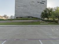 the grass area is empty of people near a building and a street sign in front