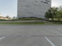 the grass area is empty of people near a building and a street sign in front