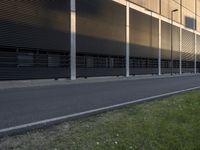 the side of an office building with a man walking down the side walk near by