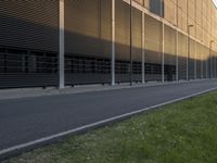 the side of an office building with a man walking down the side walk near by