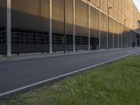 the side of an office building with a man walking down the side walk near by