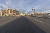 the cars have been traveling down the empty road and a city background is blurredd in