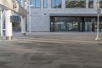 a long sidewalk outside a building with white pillars and columns in it and there are signs next to the walkway