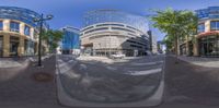 a fish eye view of two buildings in the city side by side as viewed in a mirror