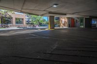 a person walks down an empty parking lot where no cars are parked, and there is the sun peeking over it