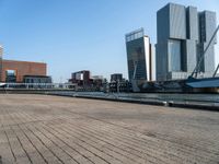 a brick walkway in front of tall buildings along a body of water in a city