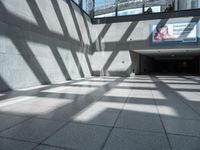 shadow from the sun on a building wall and walkway with a sign that reads,'this place is a hospital in america