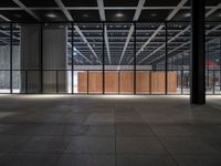 a concrete floor in front of an open area with a wooden wall at the back