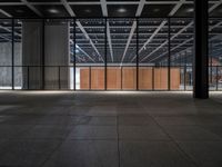 a concrete floor in front of an open area with a wooden wall at the back