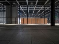 a concrete floor in front of an open area with a wooden wall at the back