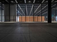 a concrete floor in front of an open area with a wooden wall at the back