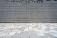 a man riding a skateboard in front of a wall with a word humsodi forum