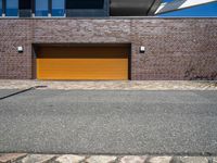 a brick building with a tan garage door next to it and the sky above it