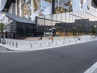 a man walking on a city sidewalk past a glass building with several spires in the background