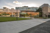 a large building that has a glass and stone facade in it's center of a grassy area near many trees